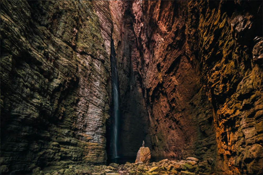 Paredões rochosos e águas cristalinas na Cachoeira da Fumacinha em meio à natureza selvagem da Chapada